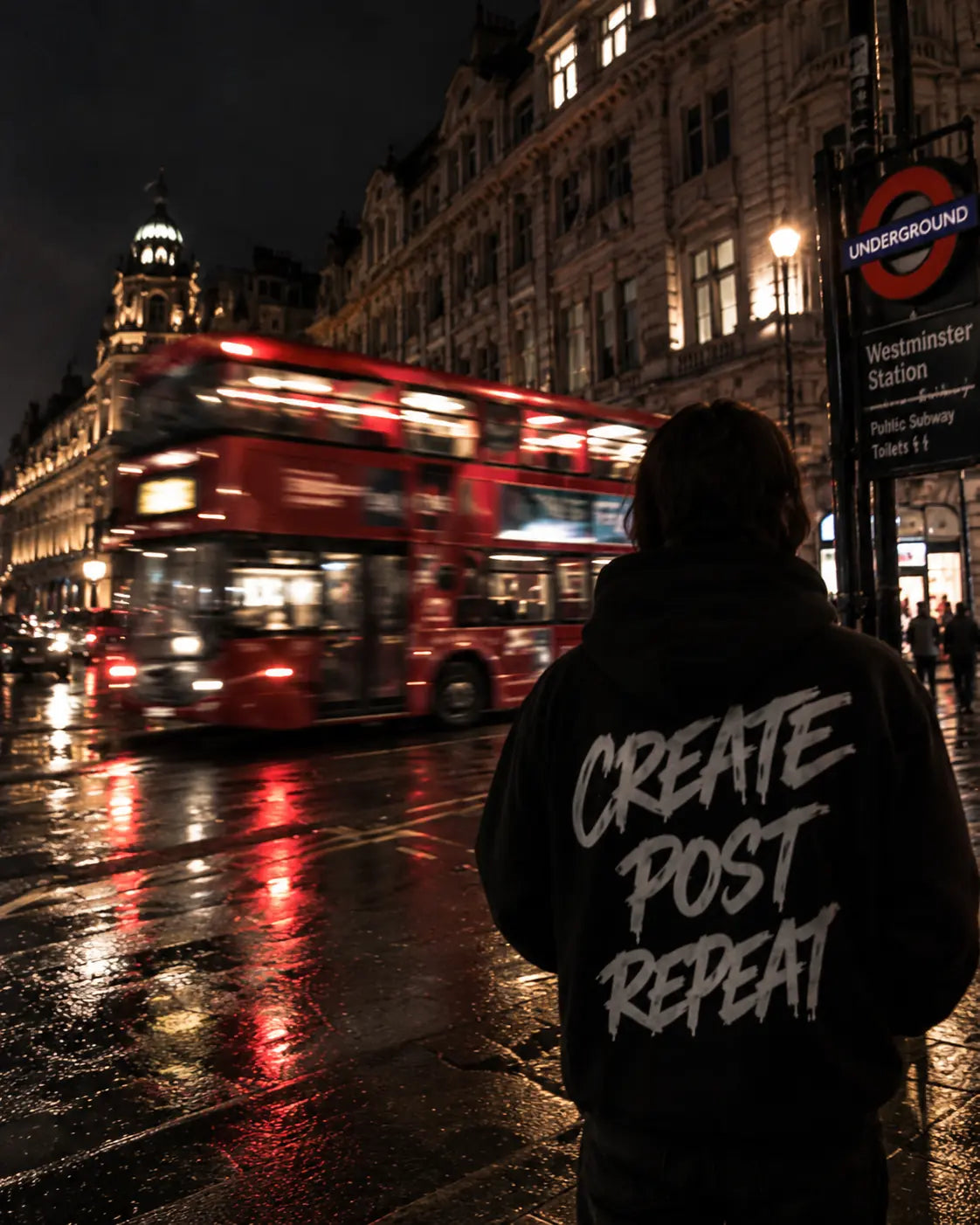 A creative professional beside a red city bus at night
