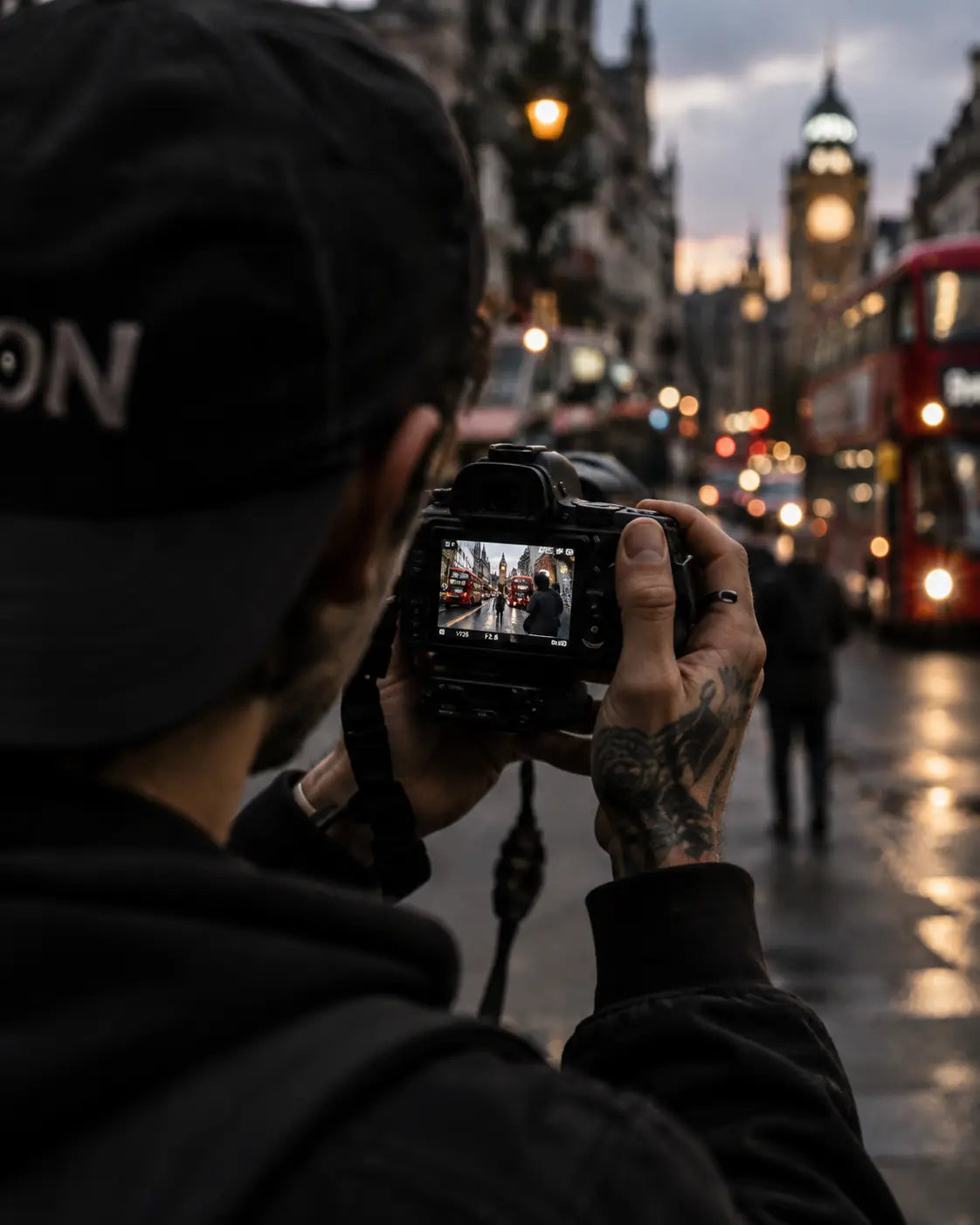 Street photographer documenting a rainy city scene at night